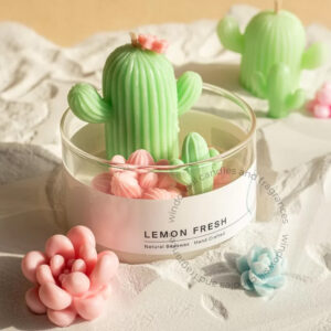 A decorative cactus garden candle by Windowsill, featuring a detailed green cactus candle surrounded by small, handcrafted wax flowers in a clear glass container, set against a textured backdrop.