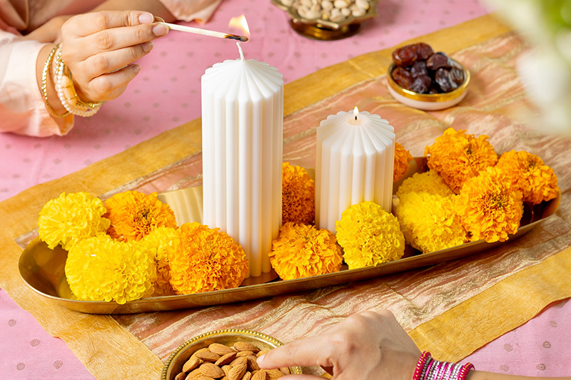 A colorful display of decorative and scented candles lighting up a festive home setup for Indian celebrations.